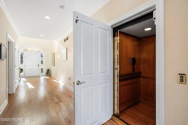 a view of a hallway with wooden floor and staircase