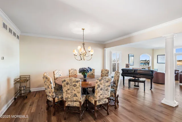 a view of a dining room with furniture wooden floor and chandelier