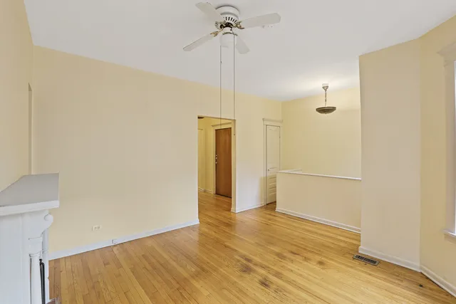 a view of a room with wooden floor and a ceiling fan