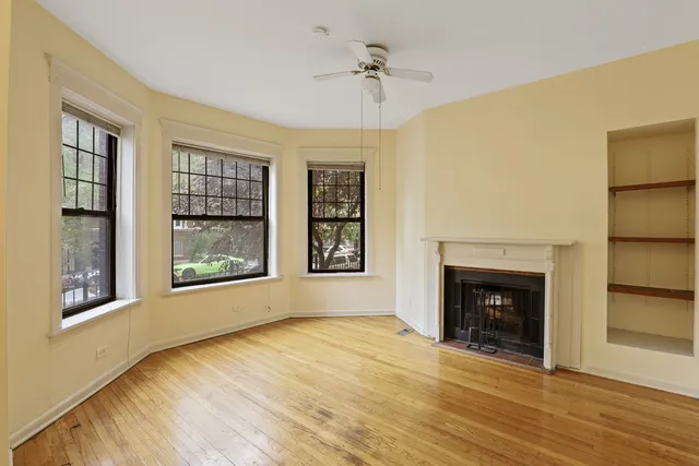 a view of an empty room with a window and fireplace