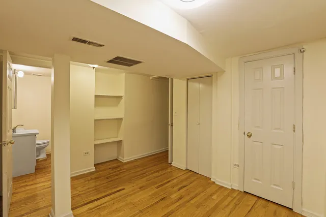 a view of a room with wooden floor and a bathroom