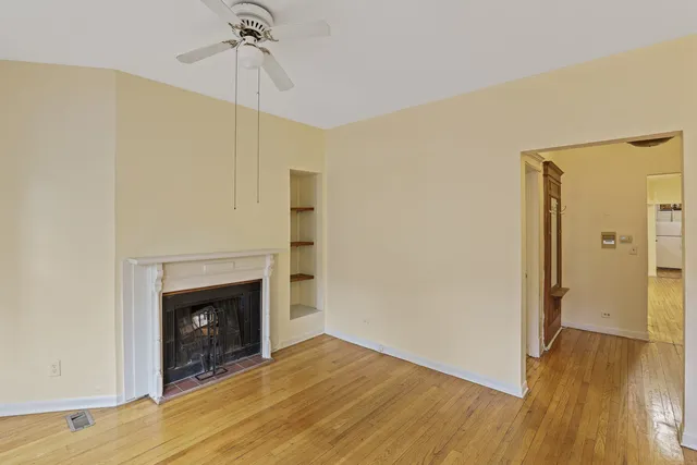 a view of a livingroom with wooden floor and a fireplace