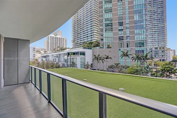 a view of a balcony with a yard