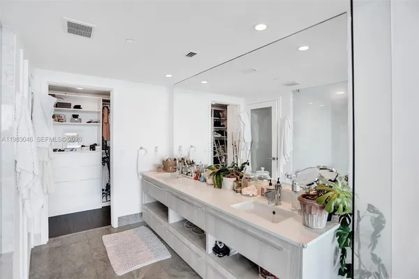 a bathroom with a double vanity sink a mirror and shower