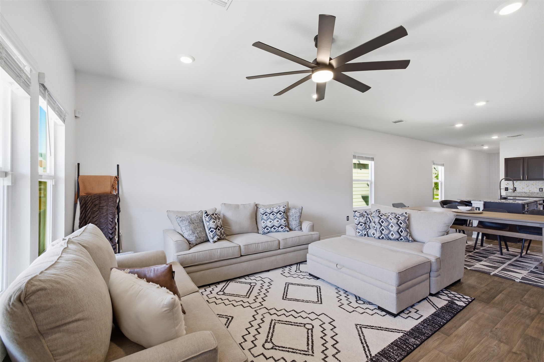 15000 Bajada Rd Manor Manor, TX 78653 - Photo 14 of 31 An inviting great room with wood flooring extends seamlessly into a modern kitchen, creating an open and fluid living space.