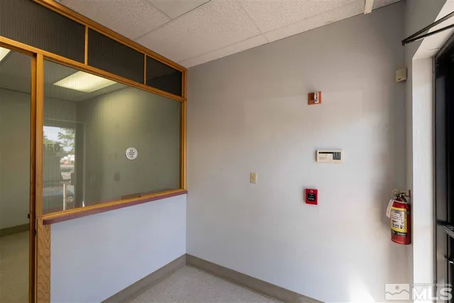 a view of a hallway with wooden floor and a living room