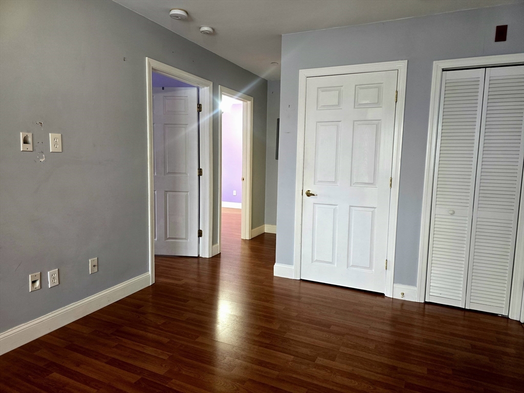 303 Eagle Street, Unit C Fall River, MA 02721 - Photo 12 of 32 an empty room with wooden floor and closet area