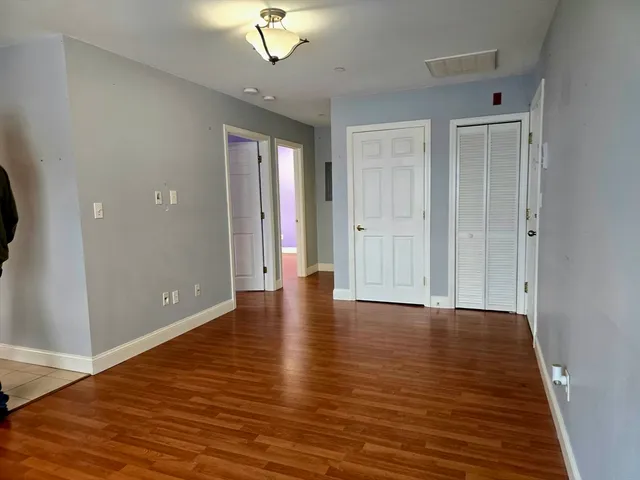 a view of an empty room with wooden floor