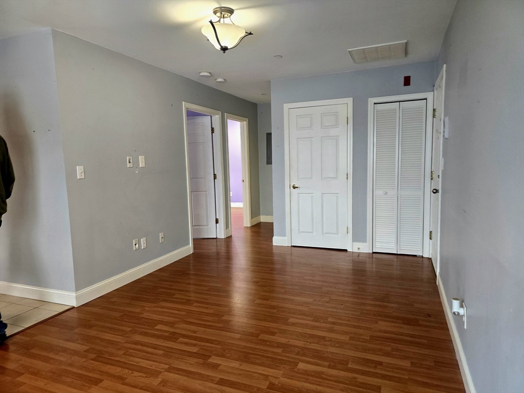 303 Eagle Street, Unit C Fall River, MA 02721 - Photo 14 of 32 a view of an empty room with wooden floor