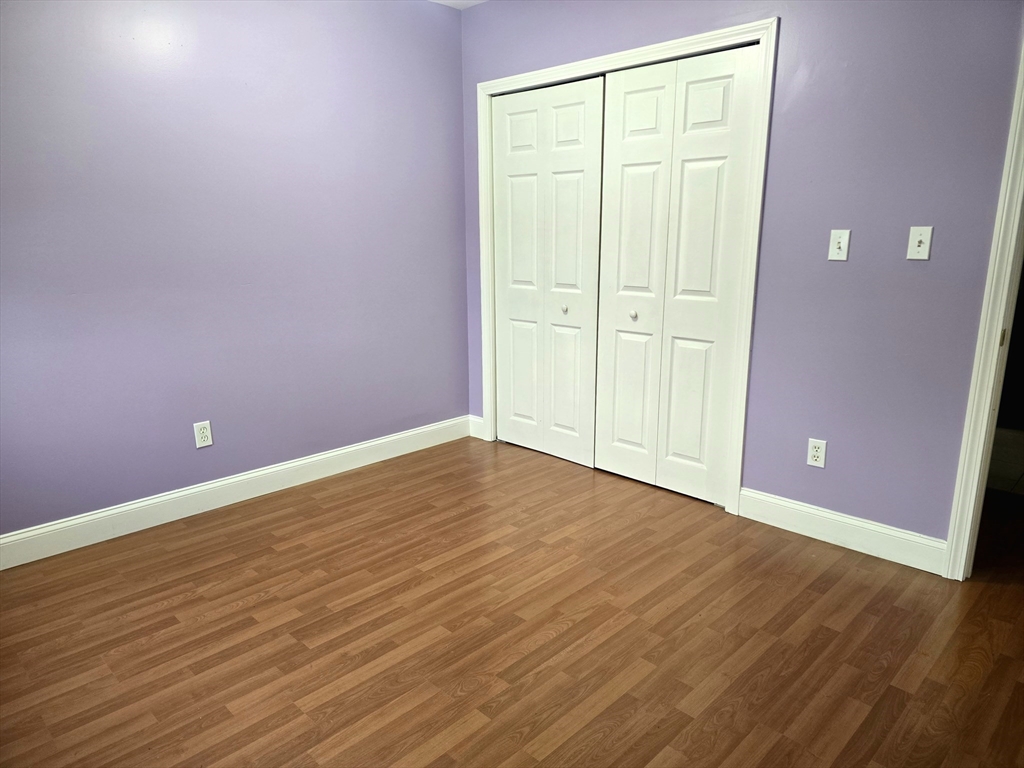 303 Eagle Street, Unit C Fall River, MA 02721 - Photo 16 of 32 an empty room with wooden floor and closet area