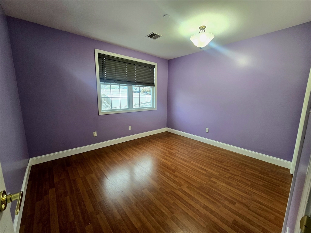 303 Eagle Street, Unit C Fall River, MA 02721 - Photo 19 of 32 wooden floor in an empty room with a window