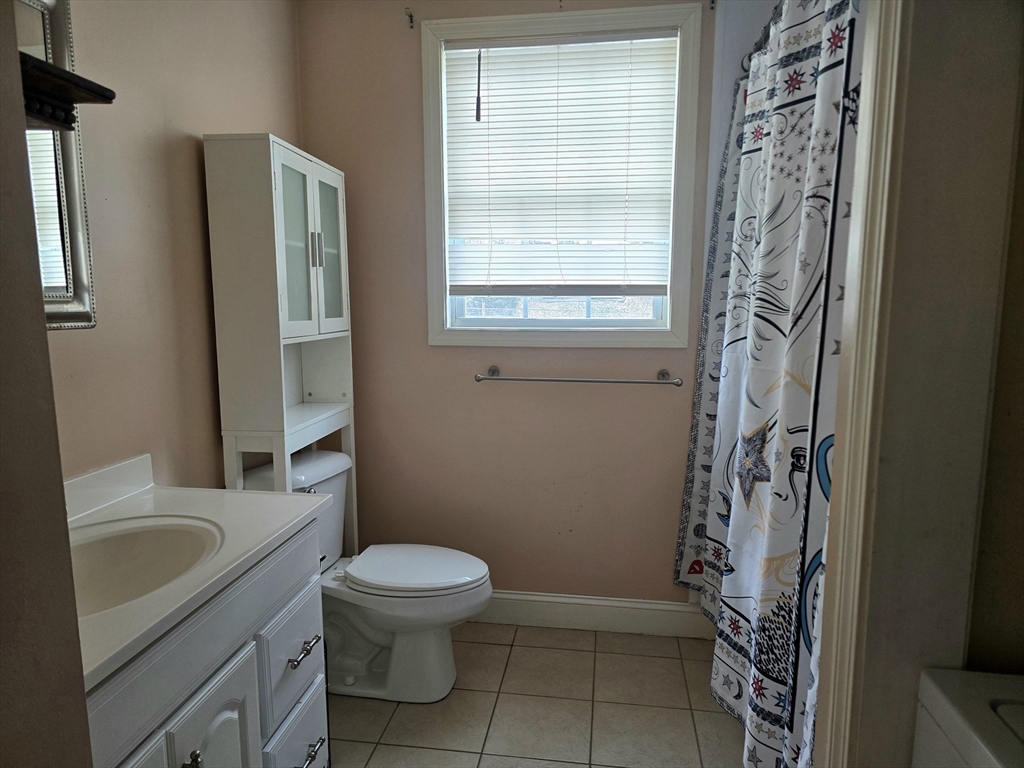 303 Eagle Street, Unit C Fall River, MA 02721 - Photo 25 of 32 a bathroom with a granite countertop toilet a sink a shower and a window