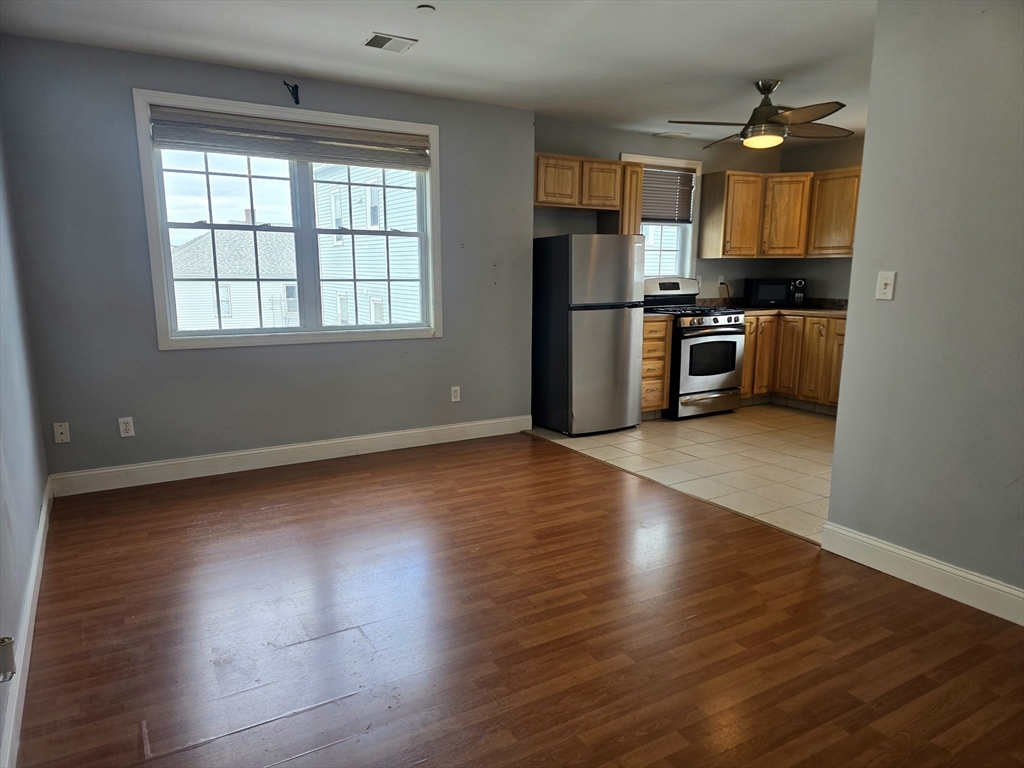 303 Eagle Street, Unit C Fall River, MA 02721 - Photo 7 of 32 a kitchen with stainless steel appliances a refrigerator and a stove top oven