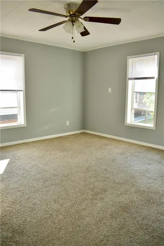 an empty room with a window and a fan