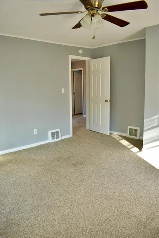 an empty room with chandelier fan