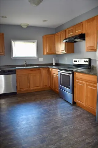 a kitchen with granite countertop wooden floors and stainless steel appliances
