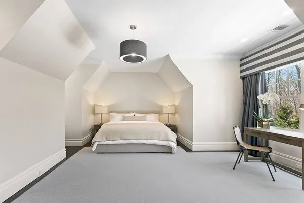 a bedroom with a bed and a large window