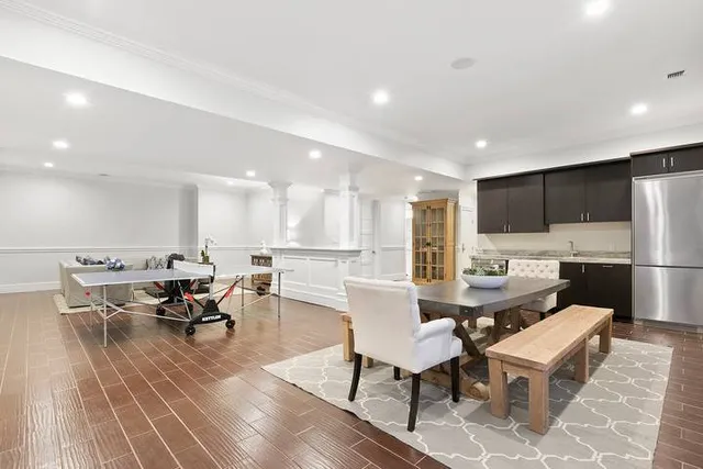 a living room with dining room and kitchen view with wooden floor