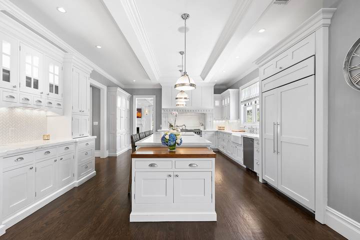 496 Wainscott Harbor Road Sagaponack, NY 11962 - Photo 5 of 20 a kitchen with granite countertop a white refrigerator a sink dishwasher and white cabinets with wooden floor