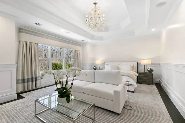 a living room with furniture large windows and wooden floor
