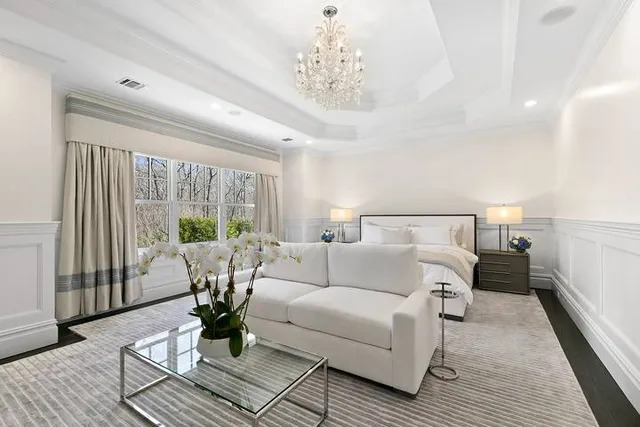 a living room with furniture large windows and wooden floor