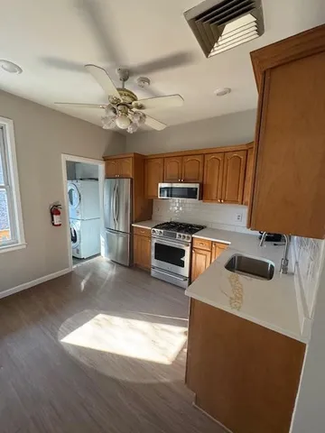 a kitchen with granite countertop a stove a sink and a refrigerator