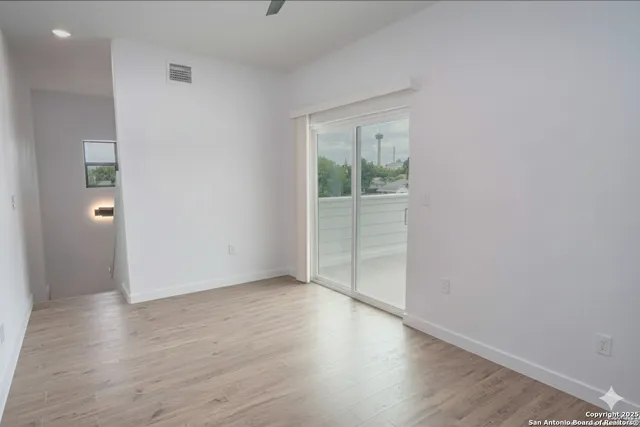 an empty room with wooden floor and a window