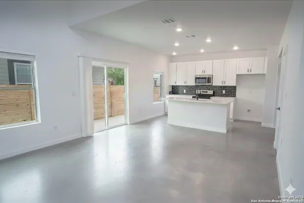 a view of a kitchen with a sink a refrigerator and window