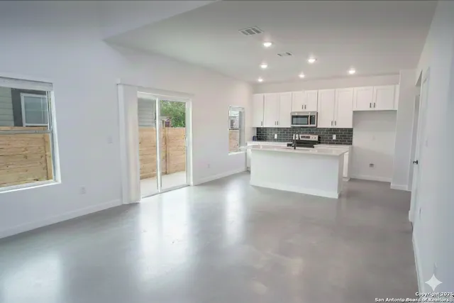 a view of a kitchen with a sink a refrigerator and window