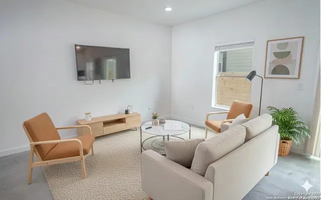 a living room with furniture and a potted plant