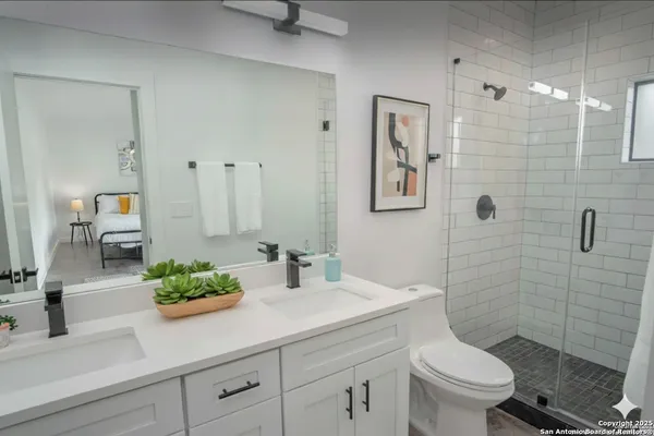 a bathroom with a sink a toilet and shower