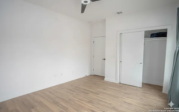 a view of empty room with wooden floor