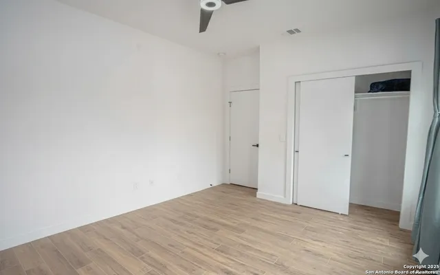 a view of empty room with wooden floor