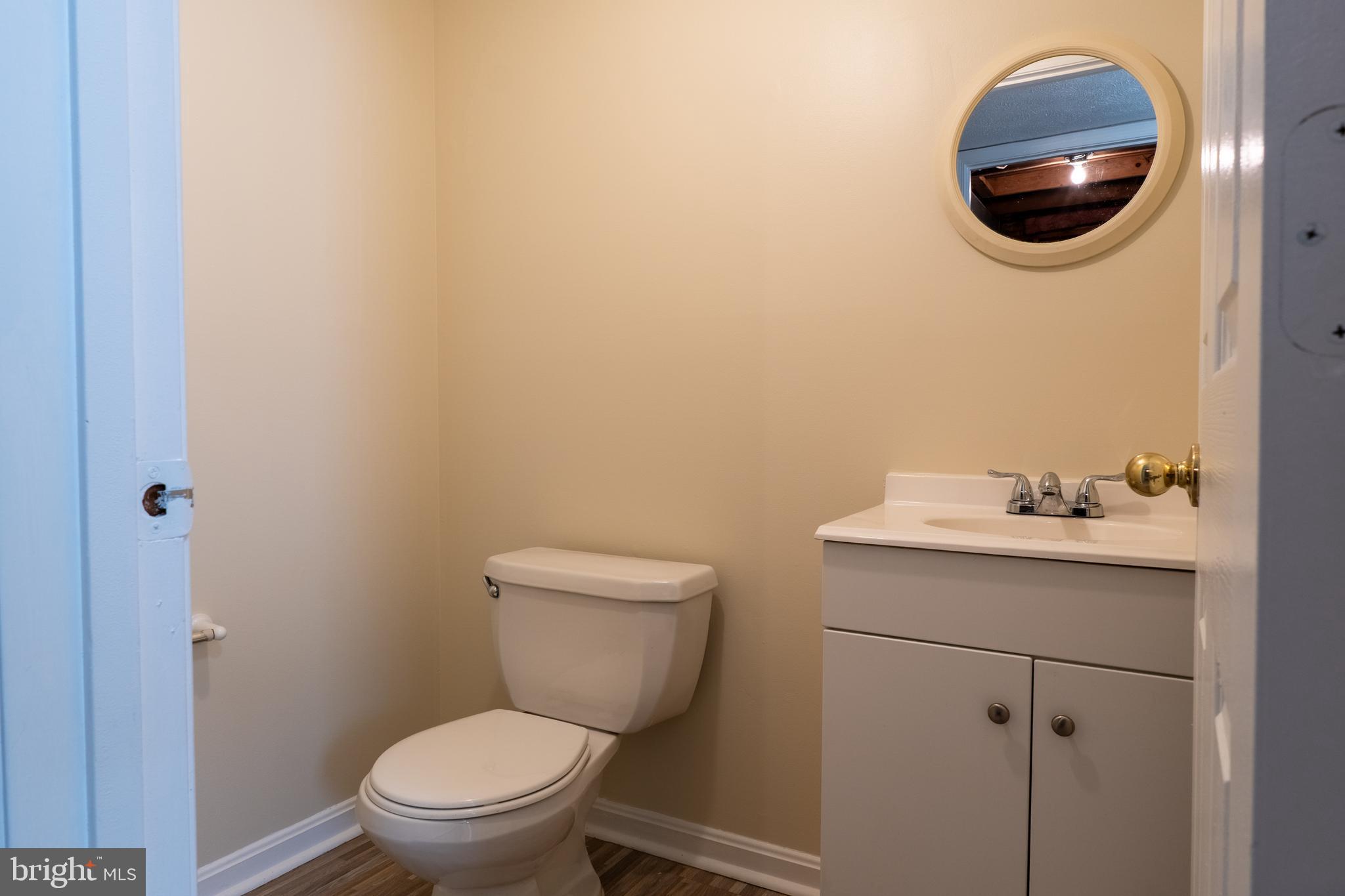 224 Oak Leaf Way Halethorpe, MD 21227 - Photo 27 of 32 a bathroom with a toilet a sink and mirror