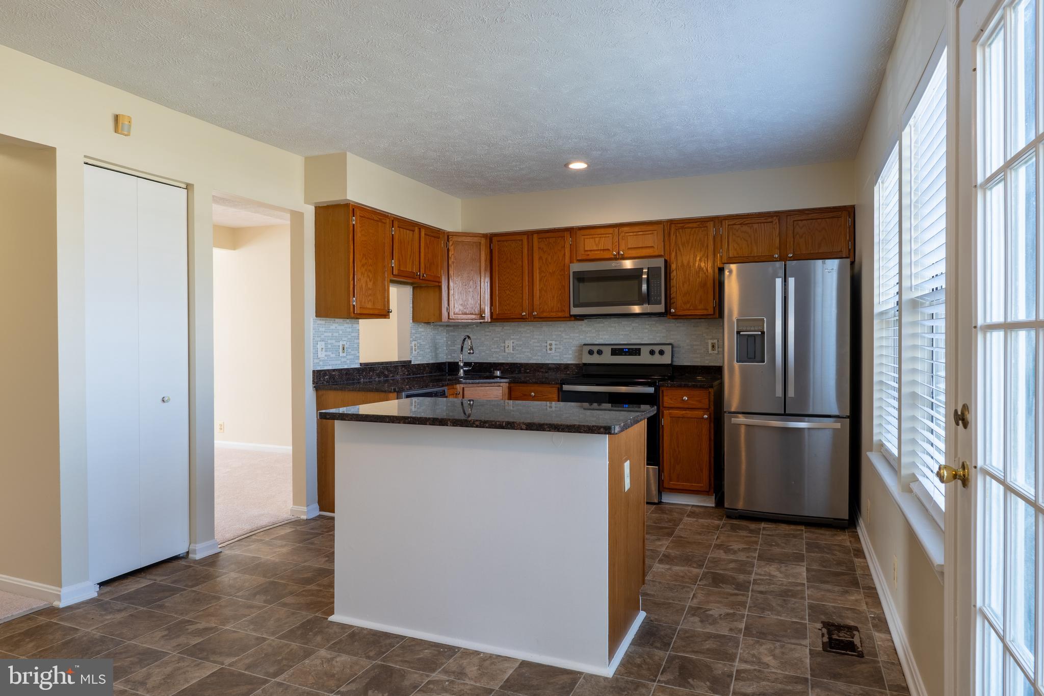 224 Oak Leaf Way Halethorpe, MD 21227 - Photo 8 of 32 a kitchen with stainless steel appliances granite countertop a refrigerator a stove a sink and a microwave