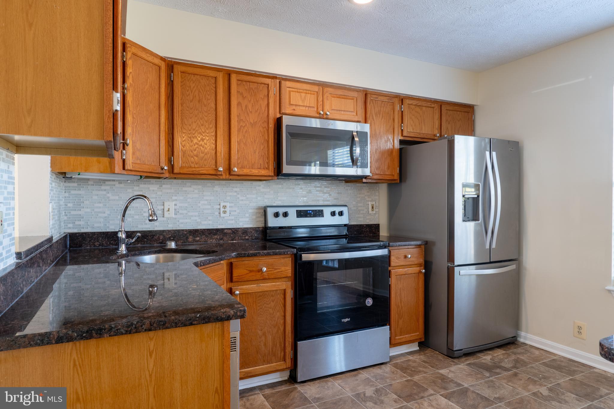 224 Oak Leaf Way Halethorpe, MD 21227 - Photo 10 of 32 a kitchen with granite countertop a refrigerator stove and sink