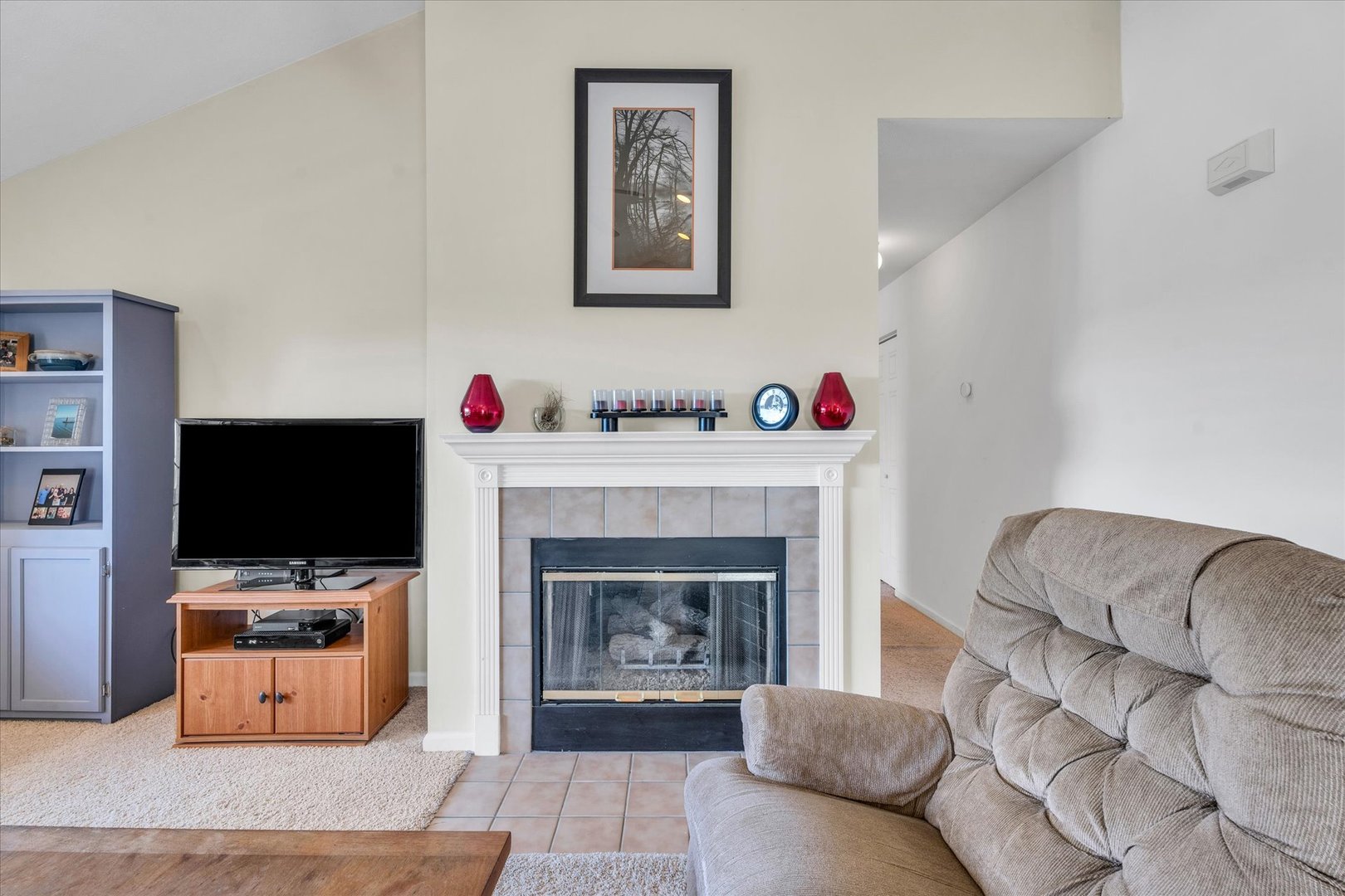 2402 Windward Boulevard, Unit 210 Champaign, IL 61821 - Photo 15 of 28 a living room with furniture a flat screen tv and a fireplace