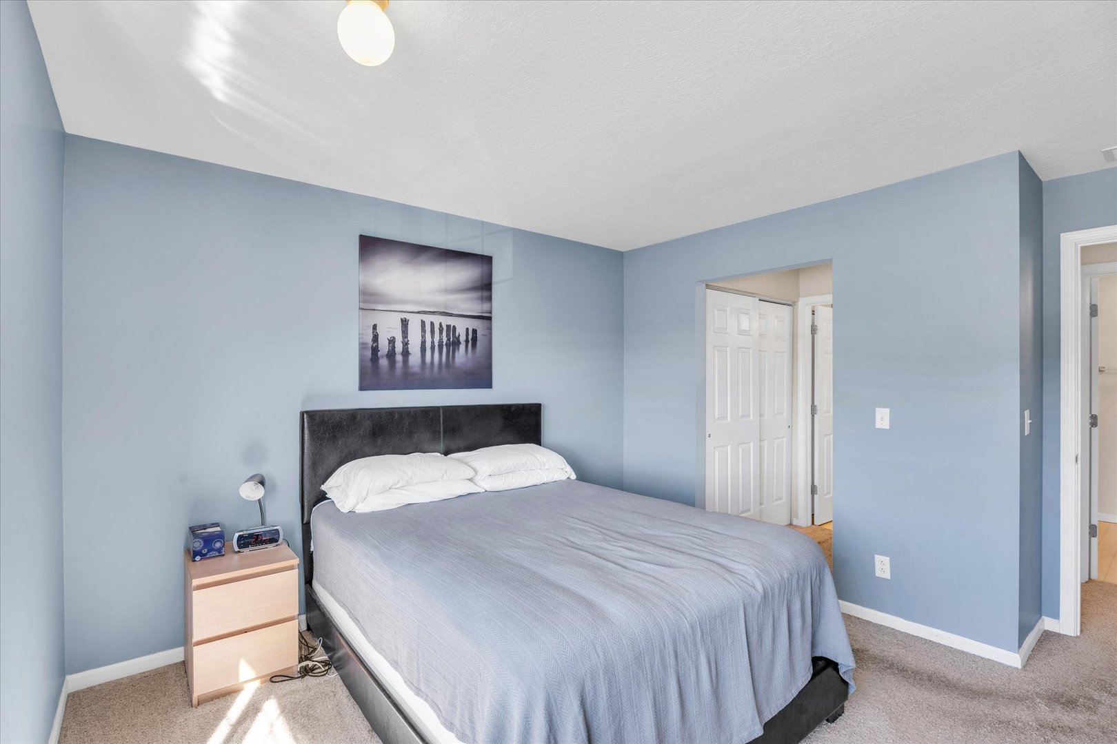 2402 Windward Boulevard, Unit 210 Champaign, IL 61821 - Photo 18 of 28 a bedroom with a bed and a lamp on table