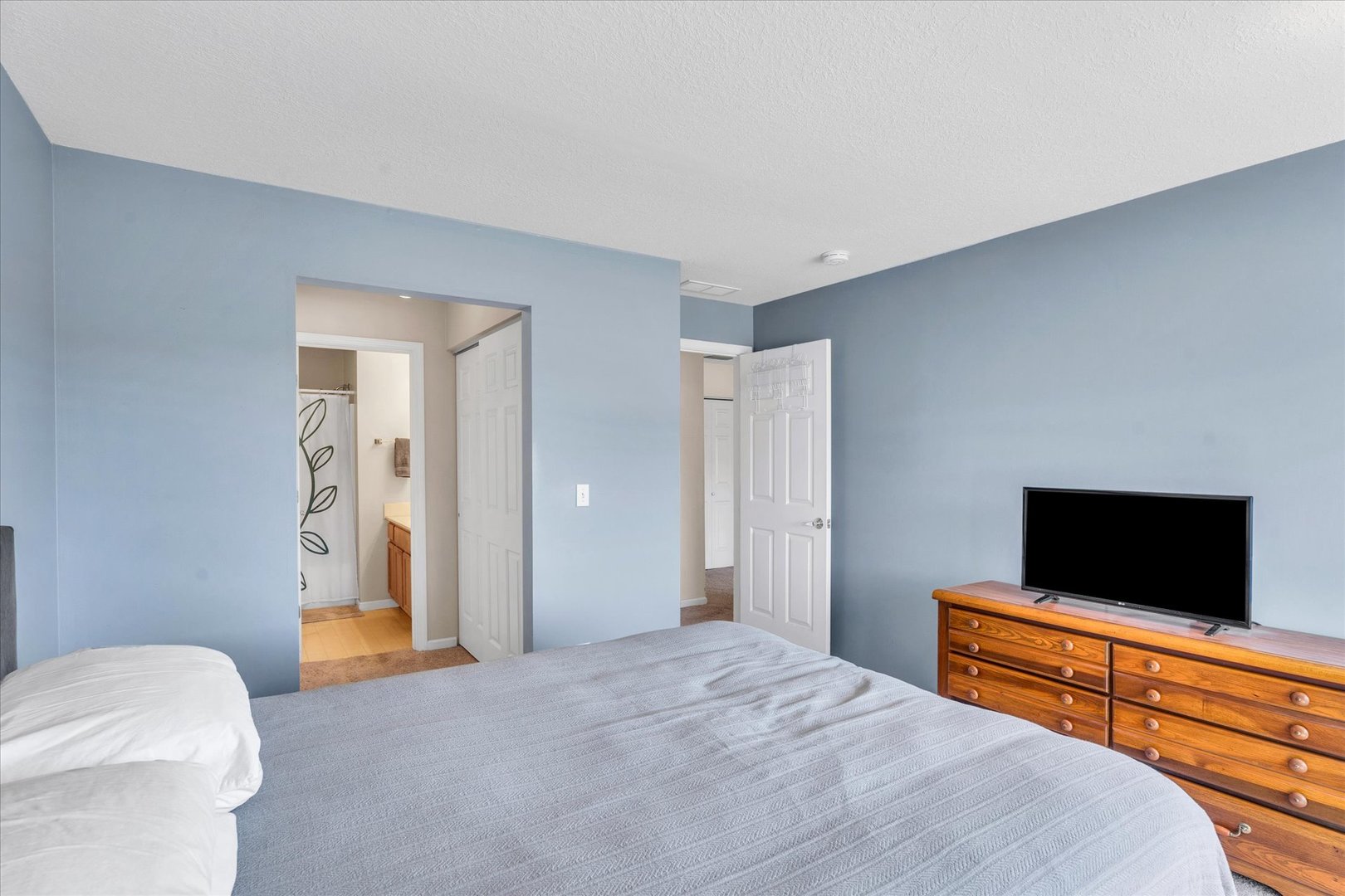 2402 Windward Boulevard, Unit 210 Champaign, IL 61821 - Photo 19 of 28 a bedroom with a bed and a flat screen tv