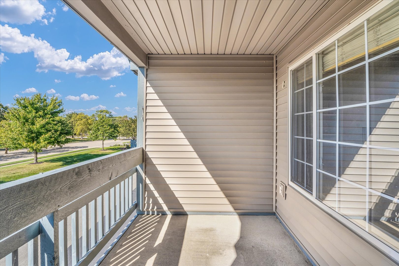 2402 Windward Boulevard, Unit 210 Champaign, IL 61821 - Photo 26 of 28 a view of a balcony with wooden floor and fence