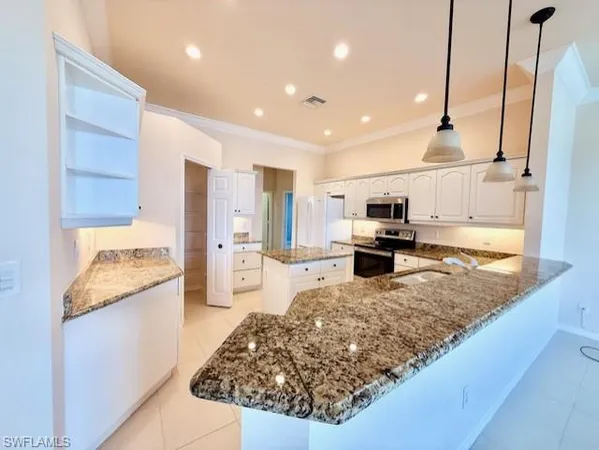 a kitchen with stainless steel appliances granite countertop a stove top oven a sink and a refrigerator