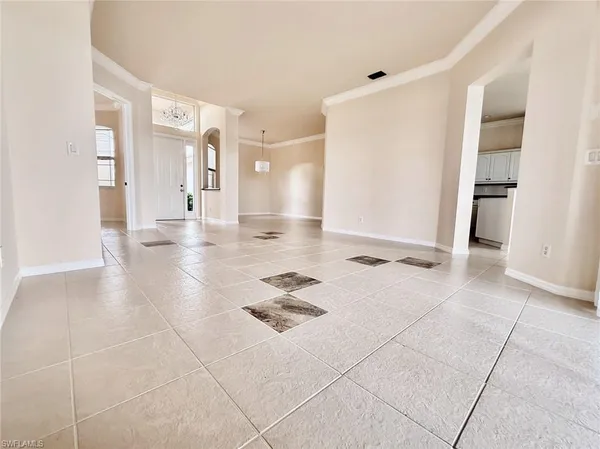 a view of a big room with windows and chandelier fan