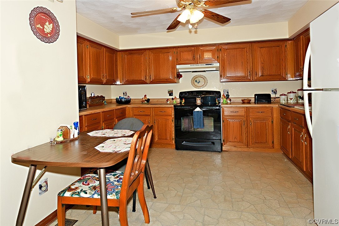 619 Spring Grove Road Spring Grove, VA 23881 - Photo 8 of 45 a kitchen with stainless steel appliances granite countertop a stove a sink dishwasher and a refrigerator with wooden cabinets