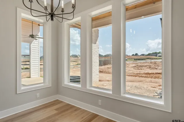 a view of a room that has a window and wooden floor