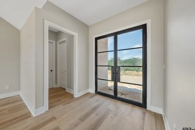a view of a room with wooden floor and a window