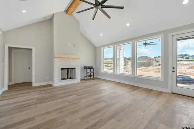 a view of an empty room with a window and fireplace