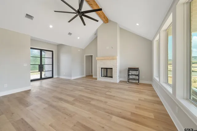 a view of an empty room with a window and a fireplace