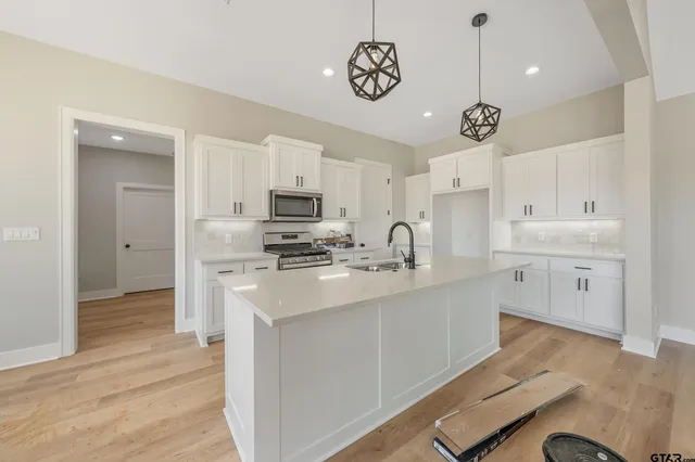 a kitchen with a sink stainless steel appliances cabinets and a counter top space