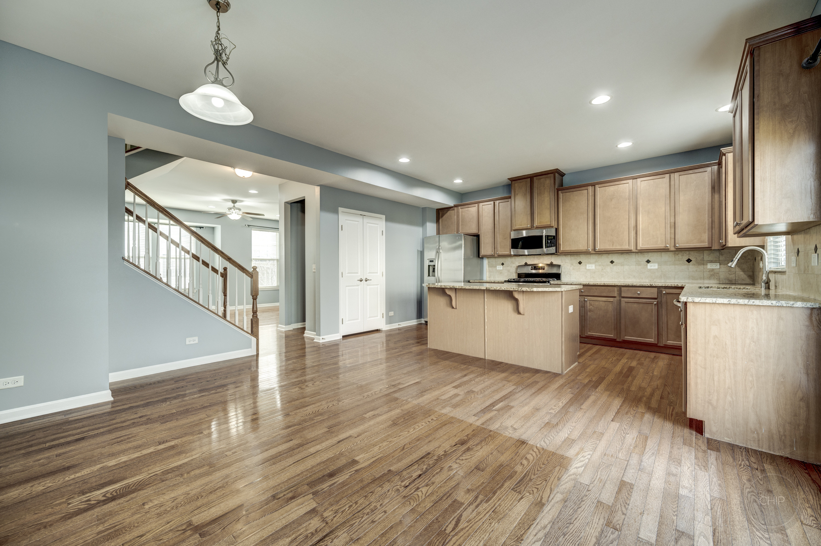 331 North Commerce Street Aurora, IL 60504 - Photo 11 of 41 a kitchen with a center island wooden floor stainless steel appliances and a window