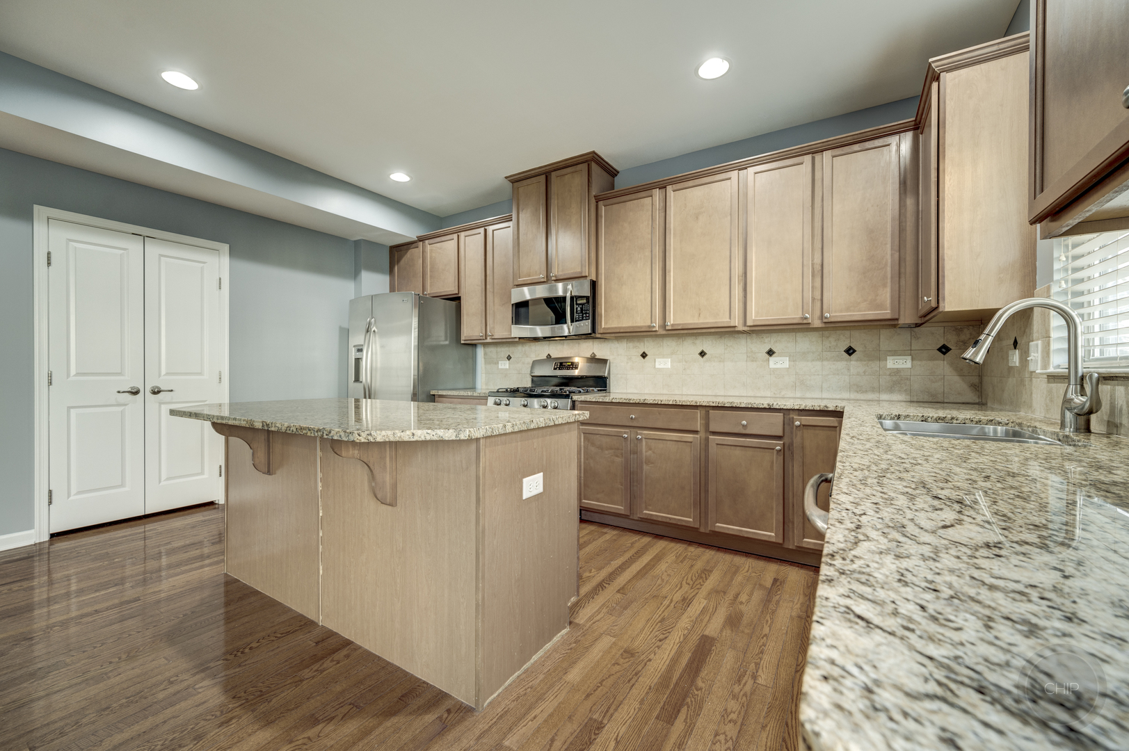 331 North Commerce Street Aurora, IL 60504 - Photo 13 of 41 a kitchen with stainless steel appliances granite countertop a sink a stove a refrigerator cabinets and a window